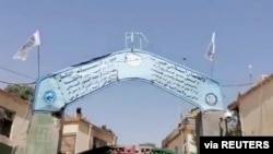 Banderas talibán ondean en la puerta de la sede de la policía en la ciudad de Ghani, Afganistán, el 12 de agosto de 2021. Foto tomada de un video divulgado por el Talibán y distribuida por Reuters.