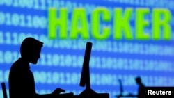 在“黑客”字樣前，一名正在操作電腦的男子。 （2021年7月5日REUTERS/Dado Ruvic插圖）