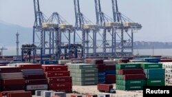 A truck drives past shipping containers at a port in Ningbo, Zhejiang province, July 9, 201
