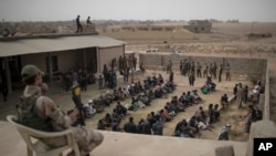 មនុស្ស​ដែល​រត់​គេច​ចេញ​ពី​តំបន់​គ្រប់​គ្រង​ដោយ​ពួក​រដ្ឋ​ឥស្លាម​ អង្គុយ​នៅ​ខាង​ក្រៅ​វិហារ​ឥស្លាម​មួយ​ការពារ​ដោយ​ទាហាន​អ៊ីរ៉ាក់ នៅ​ភាគ​ខាង​ត្បូង​ក្រុង​ Mosul កាល​ពី​ថ្ងៃទី​១ ខែ​វិច្ឆិកា។