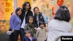 A family poses for a photograph in the World Square shopping center located in central Sydney, Australia, June 26, 2017.