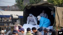 Medical personnel load the body of a victim onto a truck to be transported to Kathmandu, in Pokhara, Nepal, Jan 17, 2023.