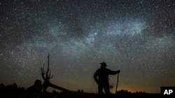 In this file photo, Dave Cooke observes the Milky Way over a frozen fish sanctuary in central Ontario, north of Highway 36 in Kawartha Lakes, Ontario, Canada, early Sunday, March 21, 2021. (Fred Thornhill/The Canadian Press via AP)
