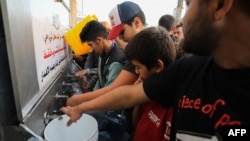 Palestininos llenan bidones de agua en la Ciudad de Gaza el 16 de octubre de 2023.