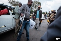 A police officer tries to protect a presidential ballot box near the tallying center in Kilgoris, Kenya, Aug. 8, 2022.