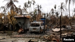 FILE - A car is seen near a house that was burnt down during the last days violence in Maungdaw, Myanmar Aug. 31, 2017.