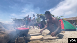 Migrantes, en su mayoría de Venezuela, cocinan en un playa de Necoclí, Colombia, el 11 de octubre de 2022. 