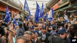Former Israeli Prime Minister and head of Likud party Benjamin Netanyahu, center, surrounded by security and his supporters, visits at Hatikva Market in Tel Aviv, Israel, Oct. 28, 2022, during his campaign ahead of the country's election. 