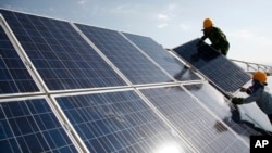 工人在中國新疆的一個光伏電站安裝太陽能電池板。