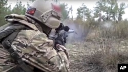 En esta foto del folleto publicada por el Servicio de Prensa del Ministerio de Defensa de Rusia el 19 de octubre de 2022, un soldado del ejército ruso dispara un rifle de francotirador en un lugar no especificado en Ucrania.