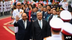 United Nations Secretary General Antonio Guterres (centre R) and Vietnam's President Nguyen Xuan Phuc (centre L) walk during a welcome ceremony at the Presidential Palace in Hanoi on October 21, 2022. (Photo by Nhac NGUYEN / AFP)