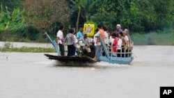 The coffin of Son Sophat, a teen victim of a boat accident, is carried in a wooden boat during a funeral procession in Koh Chamroeun village, east of Phnom Penh, Cambodia, Friday, Oct. 14, 2022.