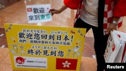 日本一家旅遊公司的員工在羽田機場歡迎一個香港旅遊團。（路透2022年6月26日）