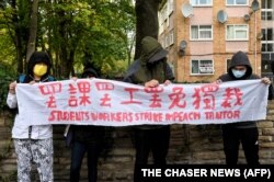 示威者在中國駐曼徹斯特領事館外手持北京四通橋懸掛反習標語的橫幅舉行抗議。（2022年10月16日）