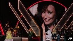 Carrie Underwood, de izquierda a derecha, Reba McEntire y Miranda Lambert rinden homenaje a la fallecida cantante Loretta Lynn, representada en la pantalla, durante la 56.ª Entrega Anual de los Premios CMA el miércoles 9 de noviembre de 2022 en el Bridgestone Arena de Nashville, Tennessee. ( Foto AP/Mark Humphrey)