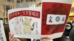 羅小姐手持標語諷刺首名確診警員，認為是上天公平制裁。(攝影: 美國之音湯惠芸）