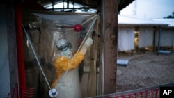 A health worker wearing a protective suit enters an isolation pod to treat an Ebola patient at a treatment center in Beni, Democratic Republic of the Congo, July 13, 2019.