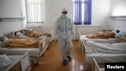 Arhiva - Zdravstveni radnik između obolelih od Kovida 19, u Zemunskoj bolnici u Begradu, 26. novembra 2020. (Foto: Rojters, Marko Đurica)