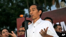 FILE - Indonesian president-elect Joko Widodo gestures as he speaks to his supporters during a gathering in Jakarta.