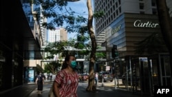 行人佩戴口罩走過香港中環的街道。（2020年7月16日）