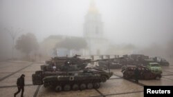ARCHIVO - Un hombre pasa junto a vehículos militares rusos destruidos afuera del Monasterio de las Cúpulas Doradas de San Miguel en una mañana brumosa, en medio del ataque de Rusia a Ucrania, en Kiev, Ucrania, el 21 de octubre de 2023.