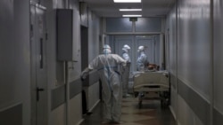 Medical staff members wearing special suits to protect against COVID-19 prepare to move a patient with coronavirus at an ICU at the Regional Clinical Hospital 1, in Krasnodar, south Russia, Tuesday, Nov. 2, 2021.