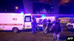 Sejunlah petugas medis dan keamanan tiba di lokasi penembakan massal di Crocus City Hall, di luar Kota Moskow, Jumat, 22 Maret 2024. (Foto: Sergei Vedyashkin/Moskva News Agency/AFP)