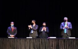 In this photo provided by Peg Shanahan, new Mayor Sokhary Chau, left, is applauded by councillors John Drinkwater, second from left, vice chair Erik Gitschier and Wayne Jenness during the Lowell City Council swearing-in ceremony, Monday, Jan. 3, 2022, in