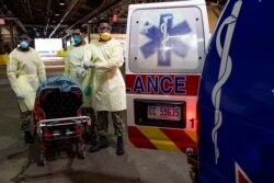 U.S. Navy Sailors prepare to transport a patient arriving for medical treatment from an ambulance onto the hospital ship USNS Comfort in New York City, April 9, 2020.