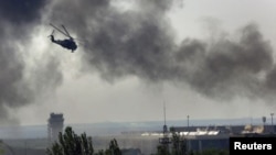 Un helicóptero Mi-24 ucraniano dispara sus cañones contra posiciones rebeldes en el aeropuerto de Donetsk.