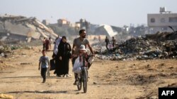 Palestinians use a path lined with destroyed buildings al-Bureij camp in the central Gaza Strip on June 2, 2024.