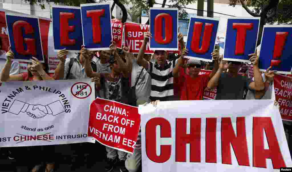 Philippine activists and Vietnamese nationals display placards and chant anti-China slogans as they march outside the Chinese consulate in Manila's Makati financial district, May 16, 2014.