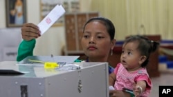 FILE - A Cambodian woman votes in the senate election at Takhmau polling station in Kandal province, southeast of Phnom Penh, Cambodia, Feb. 25, 2018. The general election is in July.