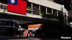 资料照片：一位男士在台北街头骑车。(2021年11月16日)