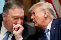 Secretary of State Mike Pompeo, left, and President Donald Trump whisper during a Cabinet meeting in the Cabinet Room of the White House, July 16, 2019, in Washington.