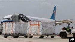 រូបឯកសារ៖ បុគ្គលិកអាកាសយានដ្ឋានអន្តរជាតិភ្នំពេញដឹកជញ្ជូនវ៉ាក់សាំងបង្ការជំងឺកូវីដ១៩ ឈ្មោះស៊ីណូវ៉ាក់ (Sinovac) របស់ប្រទេសចិន ដែលបានមកដល់រាជធានីភ្នំពេញ នៅថ្ងៃសុក្រ ទី ២៦ ខែមីនា ឆ្នាំ ២០២១។ (AP Photo/Heng Sinith)