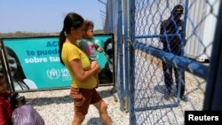 Una madre con su hijo entra al campo de refugiados de ACNUR en Maicao, Colombia, el 7 de mayo de 2019.
