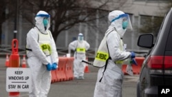 Medical personnel screen people arriving at a special COVID-19 testing site in Boston, Saturday, March 28, 2020. (AP Photo/Michael Dwyer)