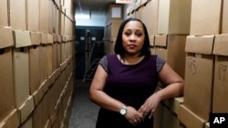 FILE - Fulton County District Attorney Fani Willis poses among boxes containing thousands of cases at her office, on Feb. 24, 2021, in Atlanta.