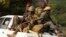 Former Seleka soldiers sit at the back of a truck during an operation of transferring all former Seleka soldiers from their main base to a smaller base north of the capital, Bangui, January 27, 2014. 
