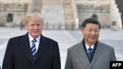 In this file photo taken on Nov. 8, 2017, US President Donald Trump, and Chinese President Xi Jinping pose at the Forbidden City in Beijing. 