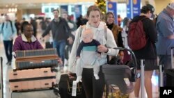 Viajeros caminan por el aeropuerto Love Field de Dallas, Texas, el 21 de diciembre de 2023 al comenzar la temporada de viajes de Navidad y Año Nuevo.