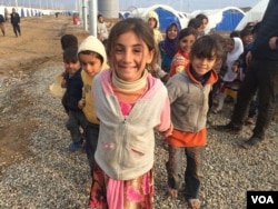 Little girls here in Khazir Camp, Kurdish Iraq say they like to pretend camp workers are giving them papers to get supplies like food and fuel on Dec. 1, 2016. (H.Murdock/VOA)