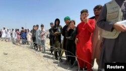 People wait outside Hamid Karzai International Airport in Kabul