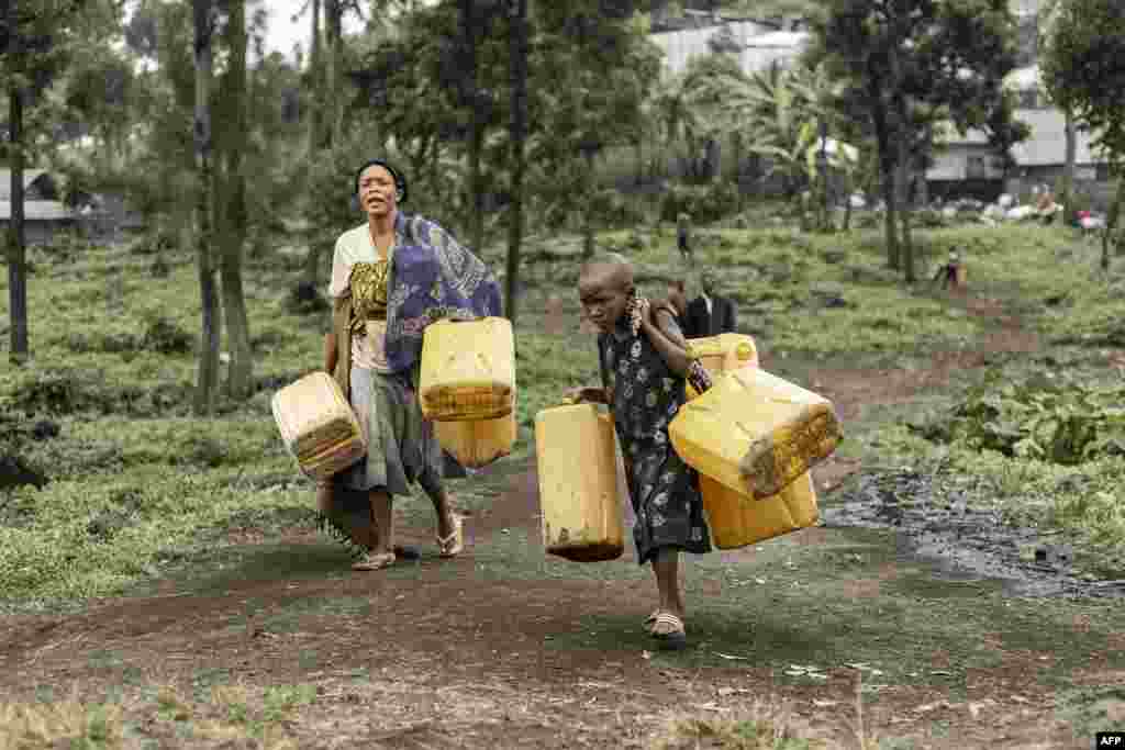Residents carry jerrycans on their way to collect water from a water point installed by Doctors Without Borders (MSF) in Mugunga, Goma, Democratic Republic of Congo. (Photo by Michel Lunanga / AFP)