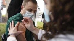 Colleen Teevan, System Pharmacy Clinical Manager at Hartford HealthCare, administers the Pfizer-BioNTech vaccine for COVID-19 to healthcare worker Connor Paleski outside of Hartford Hospital, Monday, Dec. 14, 2020, in Hartford, Conn. (AP Photo/Jessica Hil