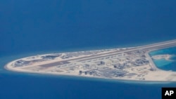 In this April 21, 2017, photo, an airstrip and buildings on China's man-made Subi Reef in the Spratly chain of islands in the South China Sea are seen from a Philippine Air Force C-130.