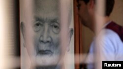 រូបឯកសារ​​៖ ទេសចរ​មួយ​រូប​មើល​រូបថត​អតីត​មេ​ដឹកនាំ​ខ្មែរ​ក្រហម​ នួន ជា ឬ «បង​ធំ​ទី​២» នៅ​សារមន្ទីរ​ប្រល័យ​ពូជសាសន៍​ទួលស្លែង​នៅ​រាជធានី​ភ្នំពេញ​កាល​ពី​ថ្ងៃ​ទី​២ ខែ​សីហា ឆ្នាំ​២០១៤។​ (REUTERS/Samrang Pring)