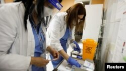 ARHIVA - Zdravstveni radnici pripremaju doze vakcine Sputnjik V protiv koronavirusa. 