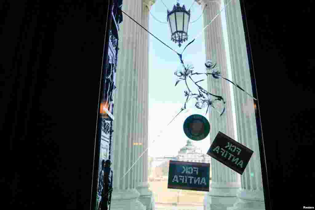 Huecos de balas y calcomanías se ven en la entrada del Capitolio. 